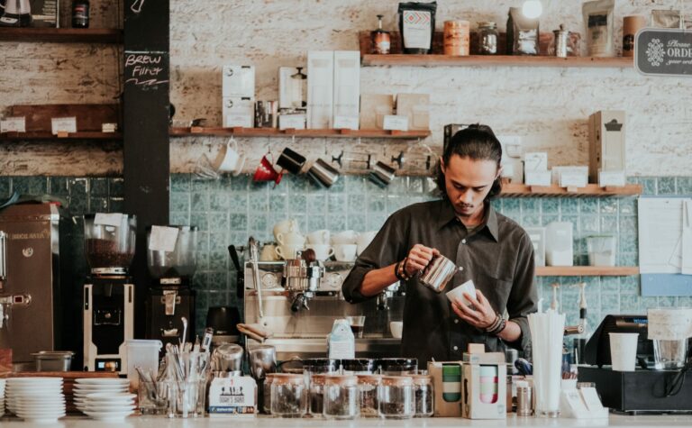 Barista making a drink by register